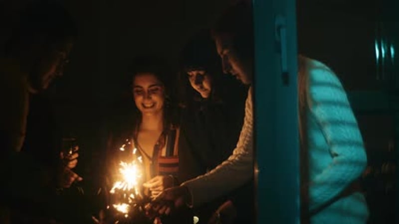 Friends celebrating new years eve with shiny sparkler
