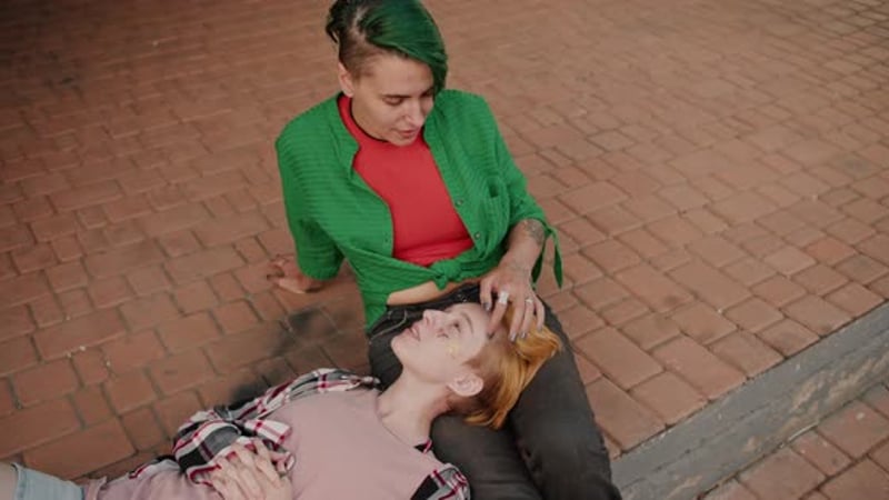 Top View of Two Lesbian Girls During Their Date Communicating with Each Other Against the Backdrop
