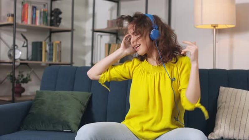 Woman in Headphones Listening Music and Dancing
