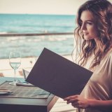 レストランでメニューを見る女性